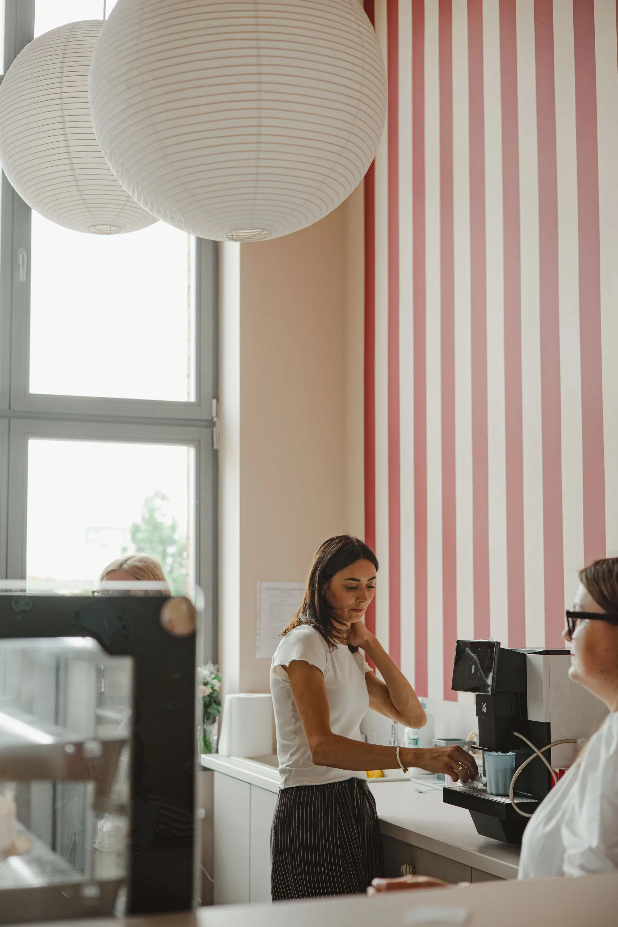 Barista przygotowująca kawę przy ladzie kawiarni